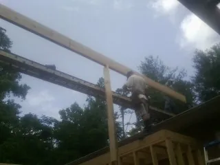 Carpenter setting a ridge beam over a new addition frame — Ice Dam Removal by Roofing Brothers in Peebles
