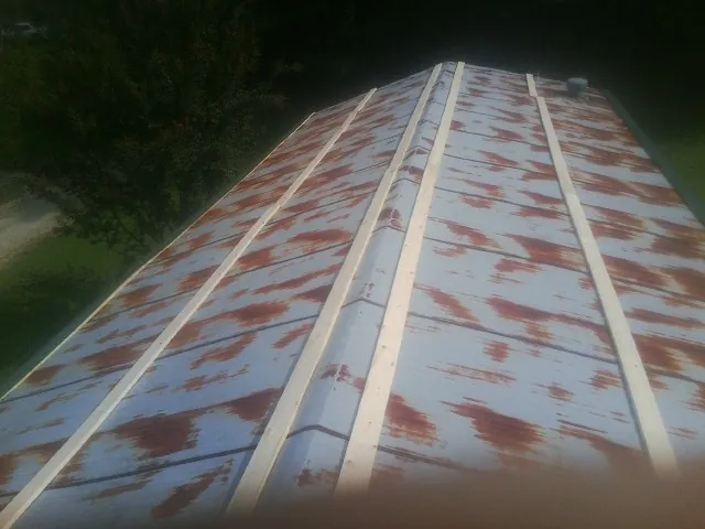 Rusted metal roof panels with new wood purlins before replacement — Storm Damage Roof Repair in Peebles by Roofing Brothers