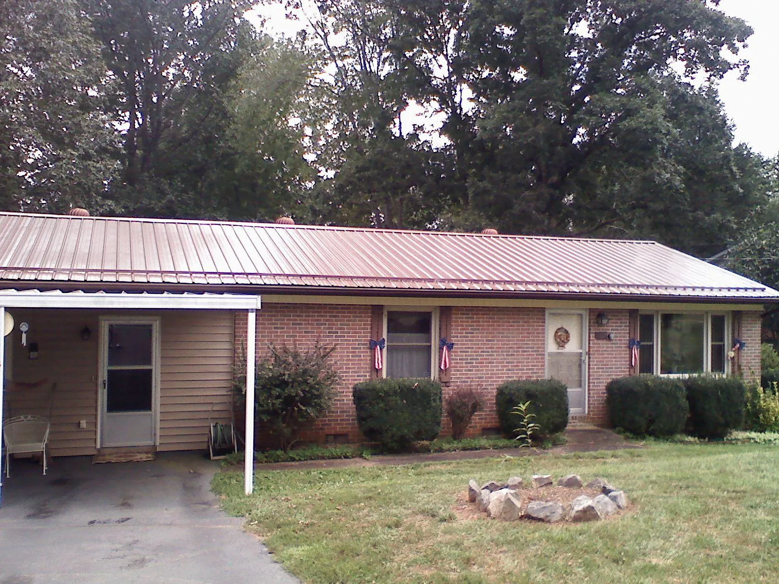Bronze metal roof and carport on a brick ranch home — Roof Repair work by our crew in Peebles